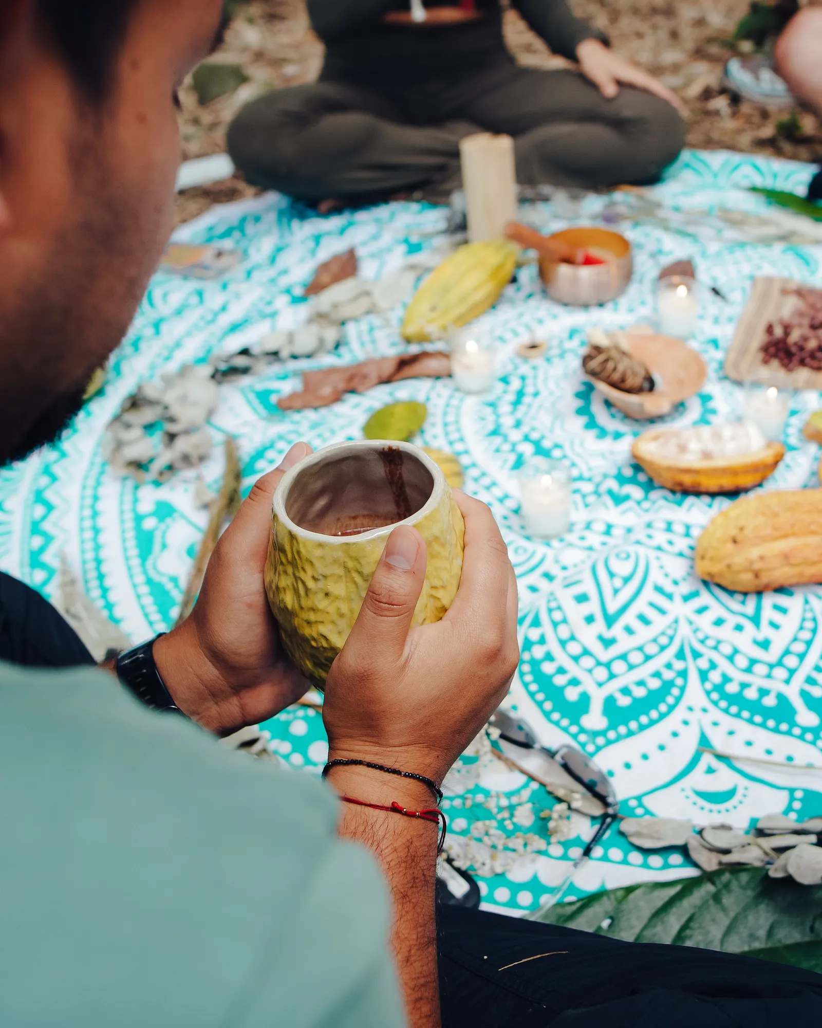 Taza de cacao en las manos durante la ceremonia de cacao