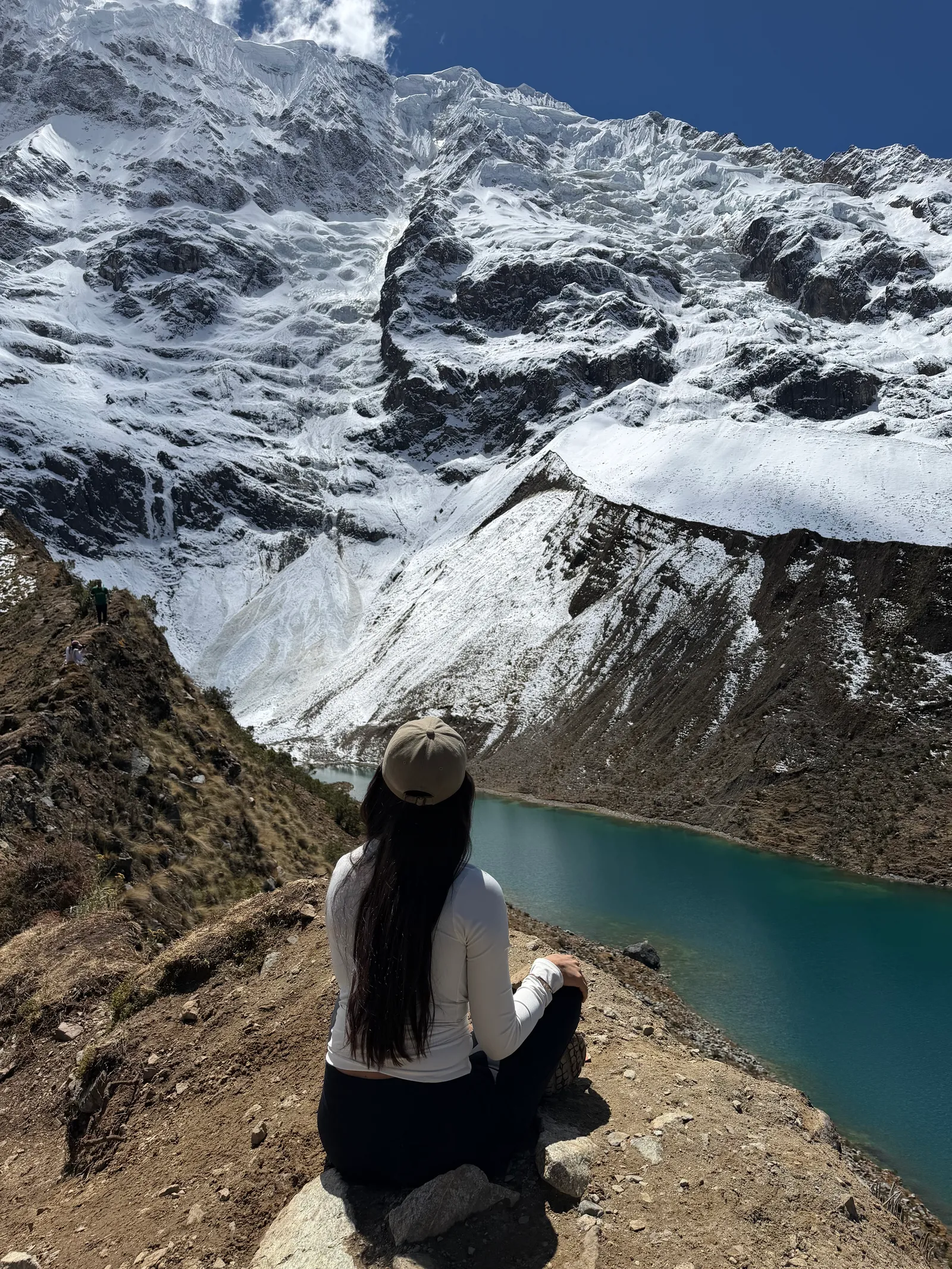 Andreina frente a una laguna turquesa a los pies de un nevado, cerca de Cusco