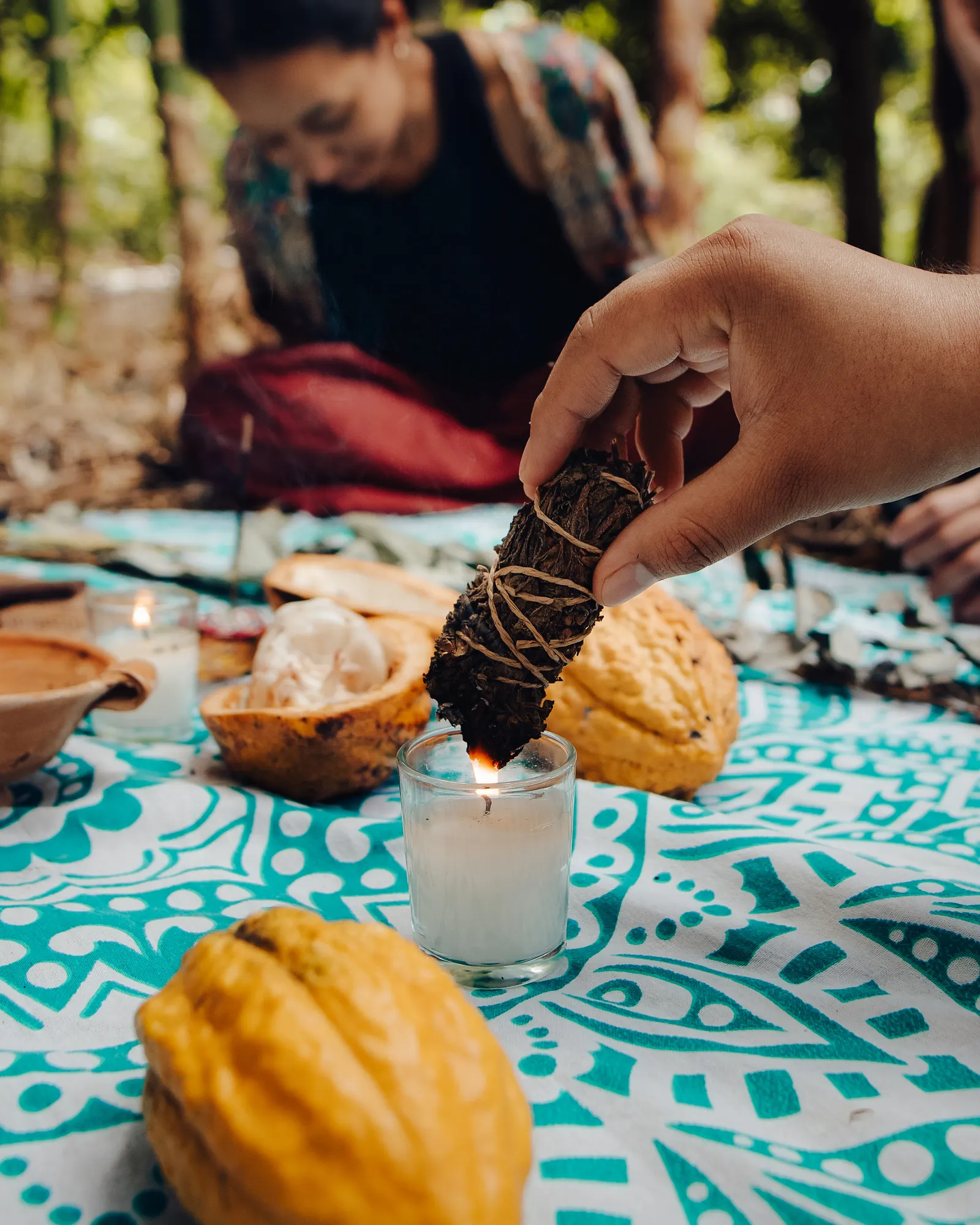 Palo santo, velas y mazorcas de cacao sobre el manto de la ceremonia